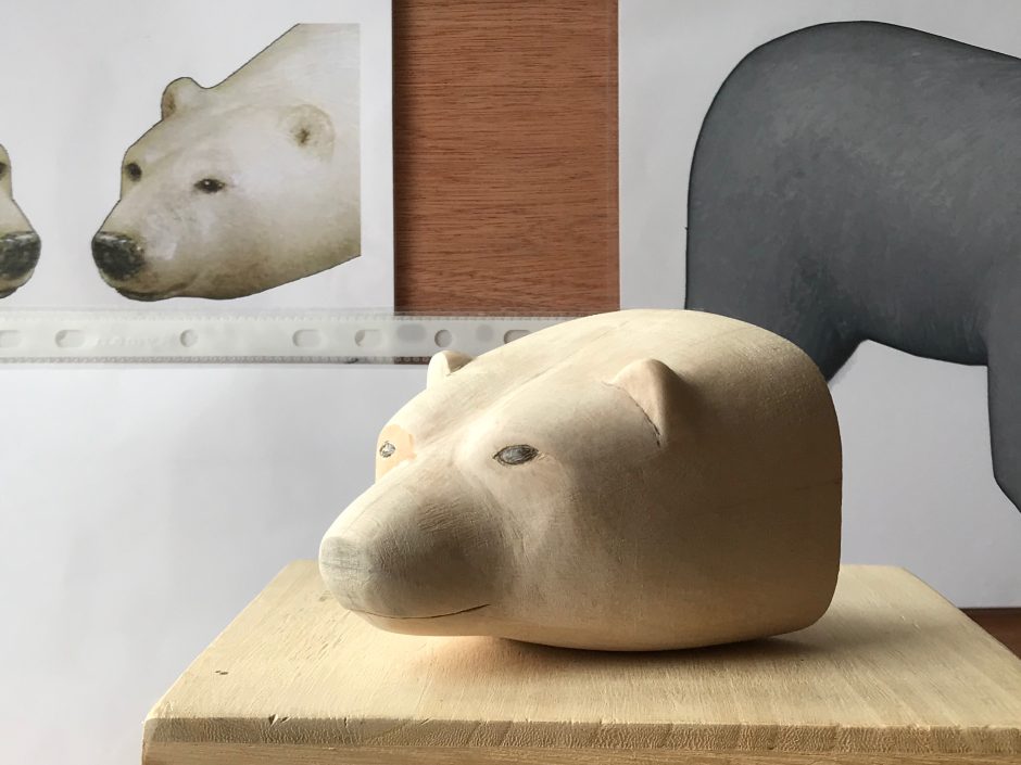 Wooden model of head of Polar bear, with reference images in background