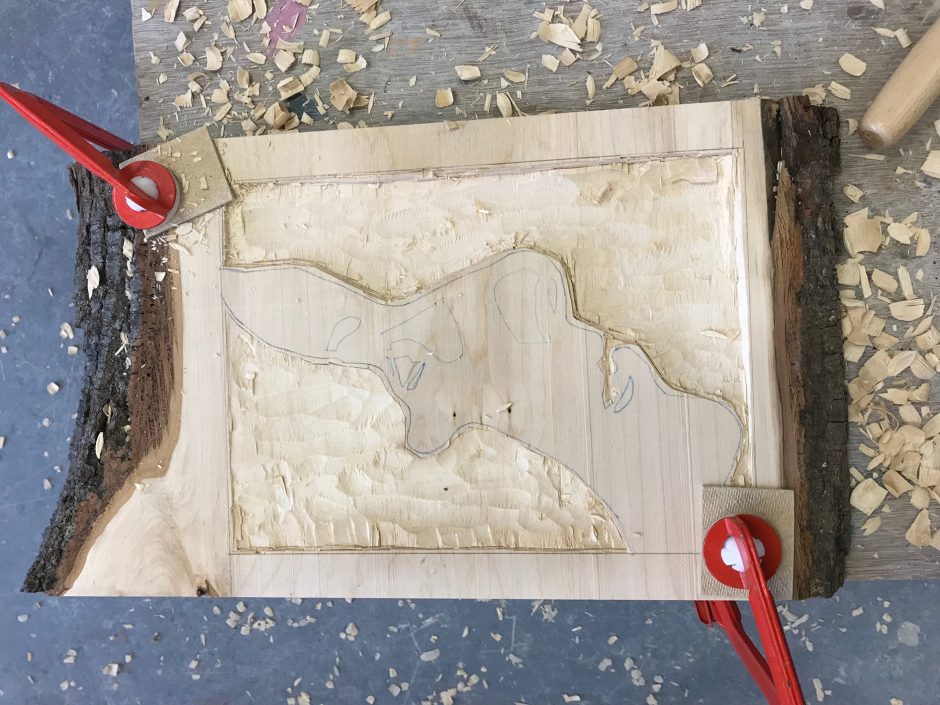 Clamped relief wood carving, a face on its side