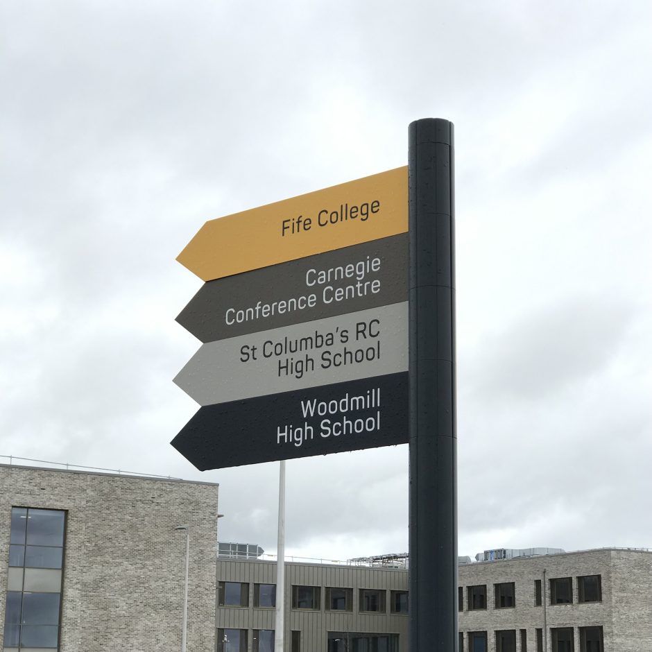 Sign from Dunfermline Learning Campus, reading from top to bottom, Fife College, Carnegie Conference Centre, St Columba's RC High School and Woodmill High School.