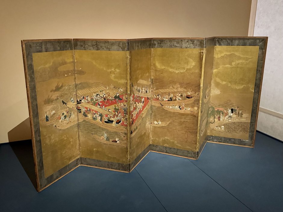 Historic Japanese folding screen showing boats on water across 6 screens which are hinged.