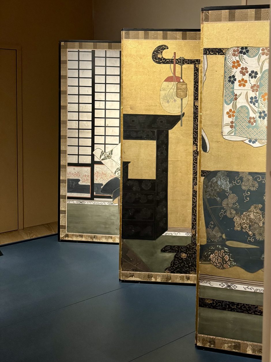 Detail of historical Japanese folding screens. Imagery includes a lamp and kimonos which are hung up rather than being worn.