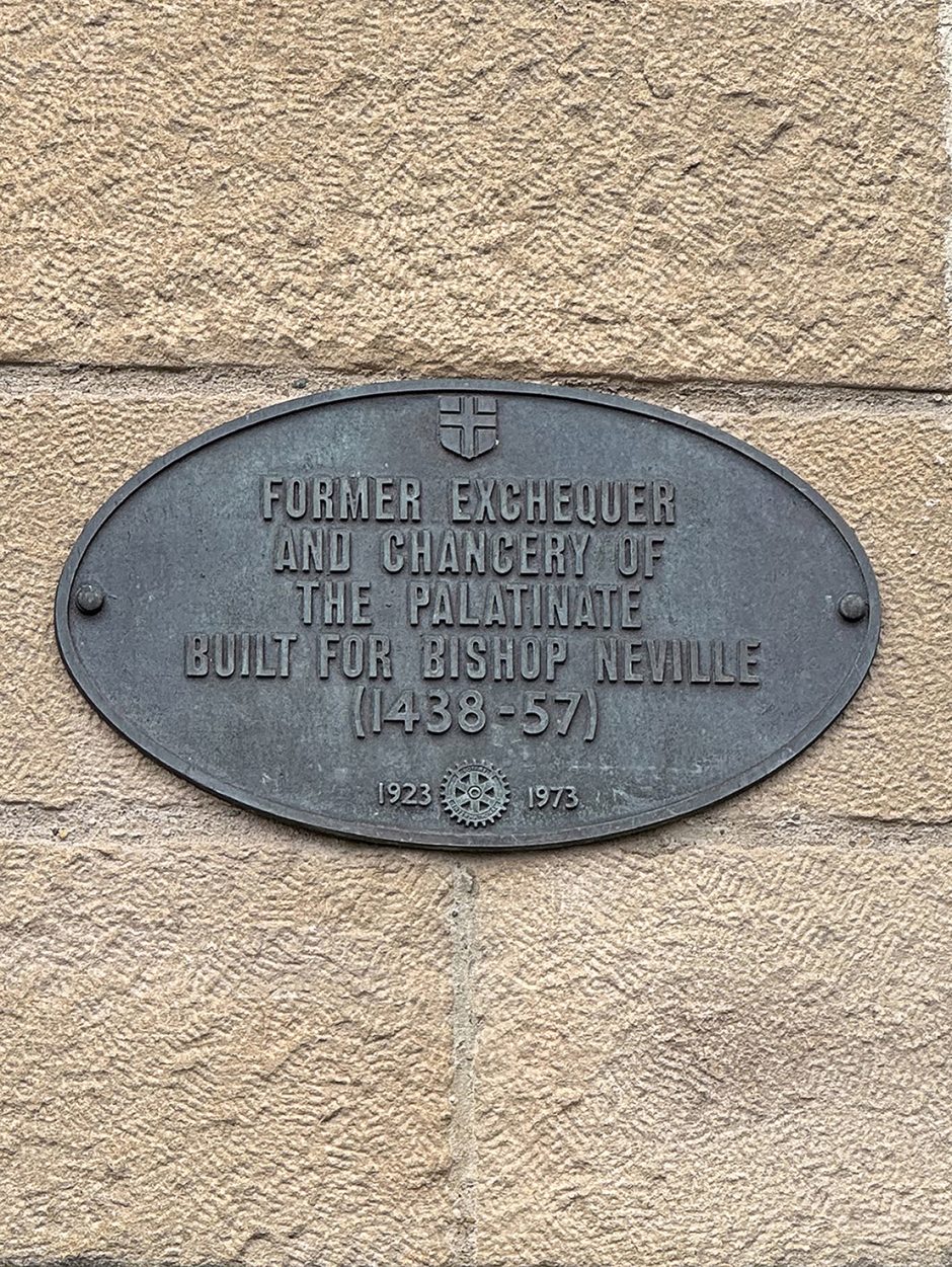 Elliptical shaped plaque with the text FORMER EXCHEQUER OF THE CHANCERY OF THE PALATINATE BUILT FOR BISHOP NEVILLE (1438-57)